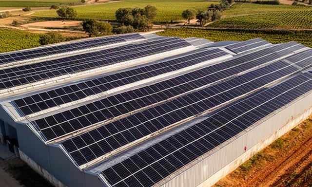 Filas de paneles solares sobre una nave de bodega en una finca de Segovia